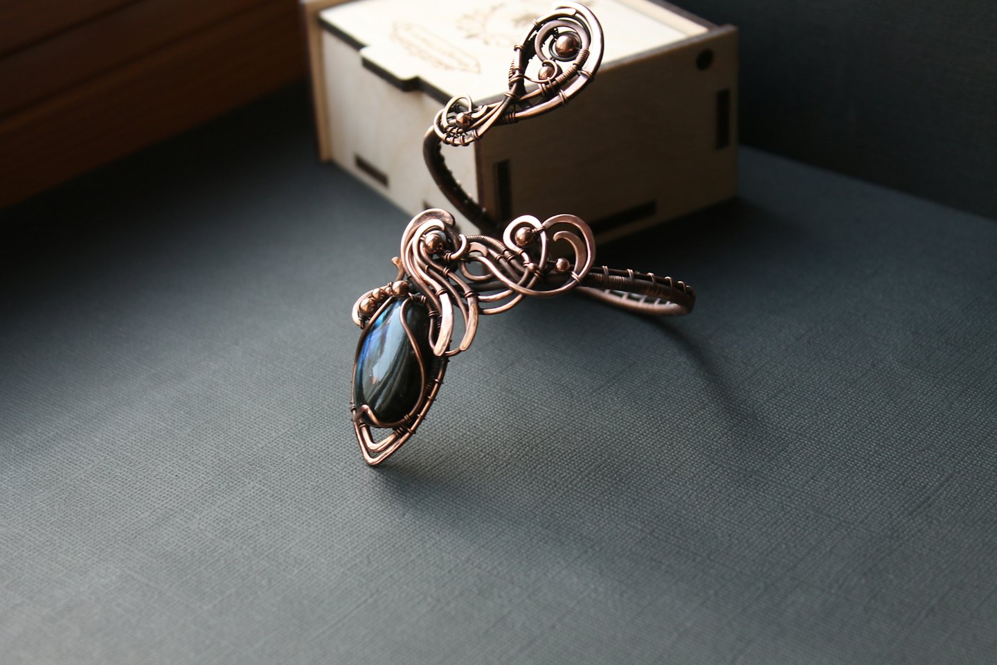 Handcrafted copper cuff bracelet featuring a dark iridescent gemstone.