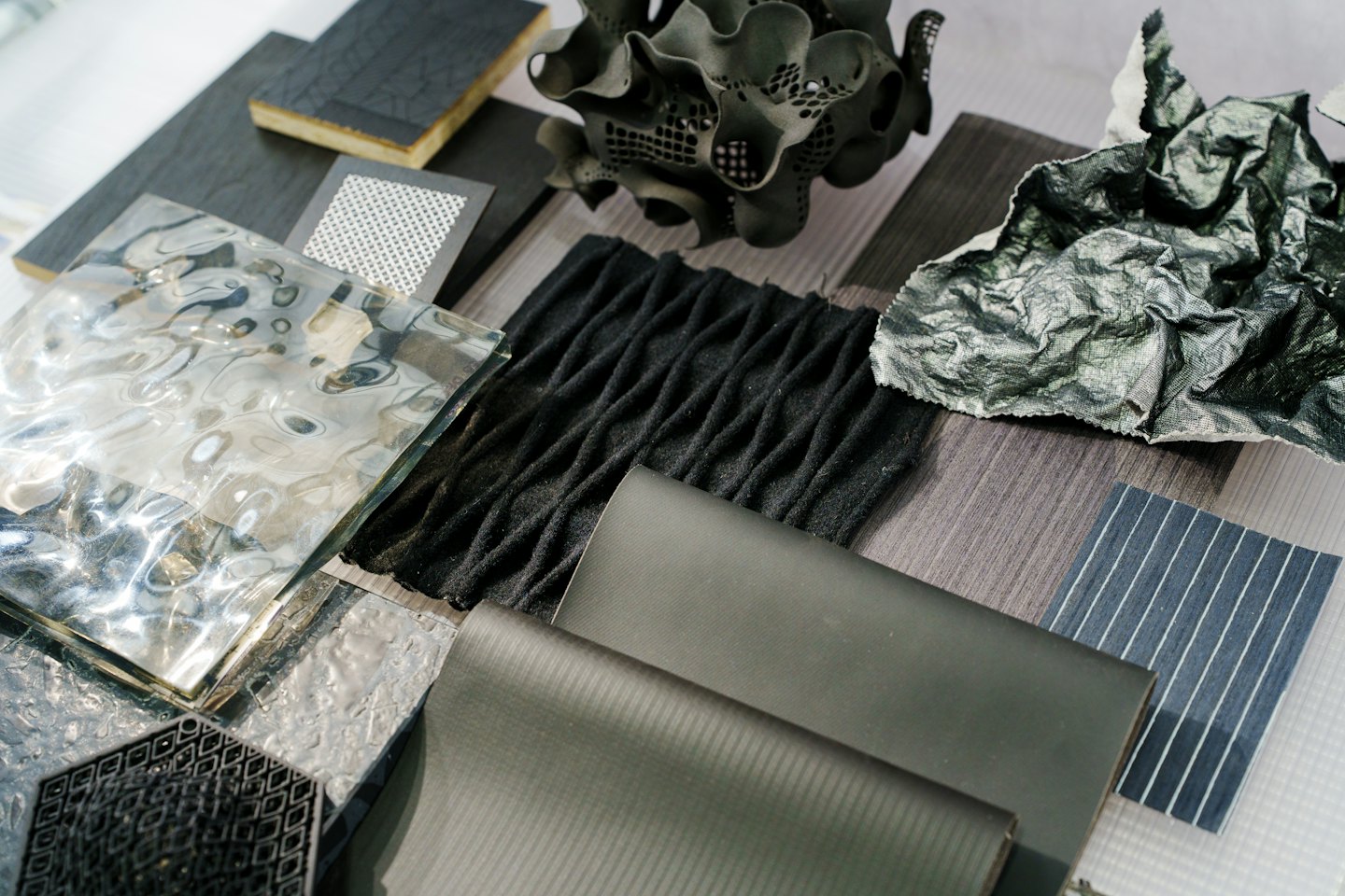 Various material samples like metal, glass, wood, and fabric arranged together.