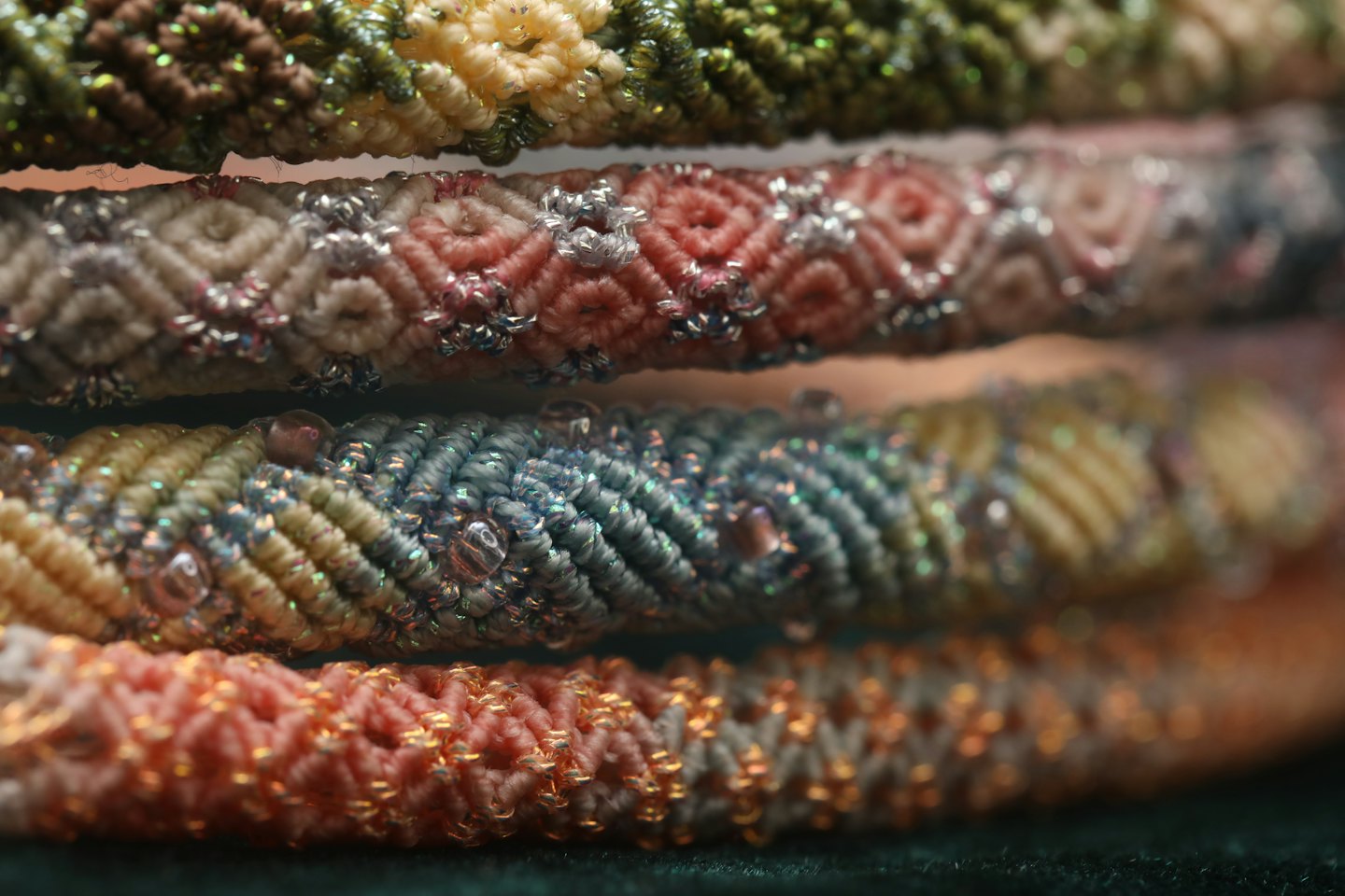 Braided bracelets with colorful woven patterns and clear beads.