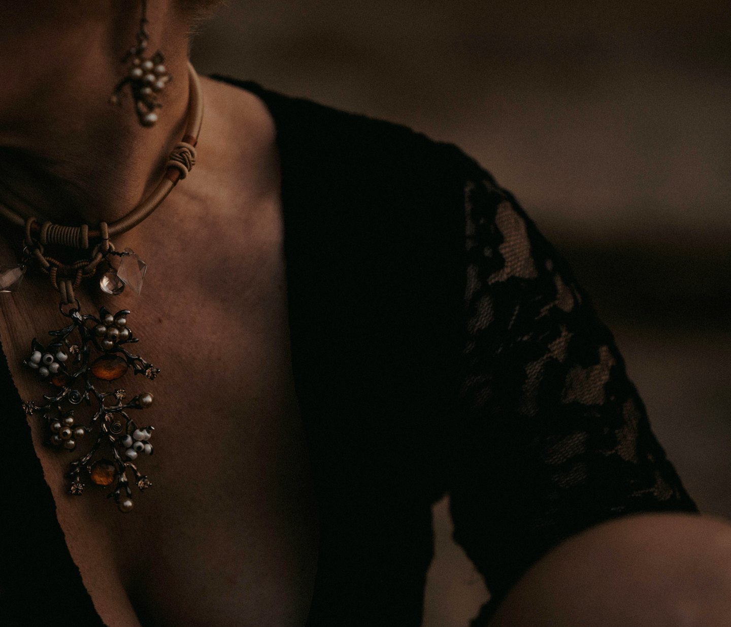 Person wearing a vintage twig-like necklace and earrings.